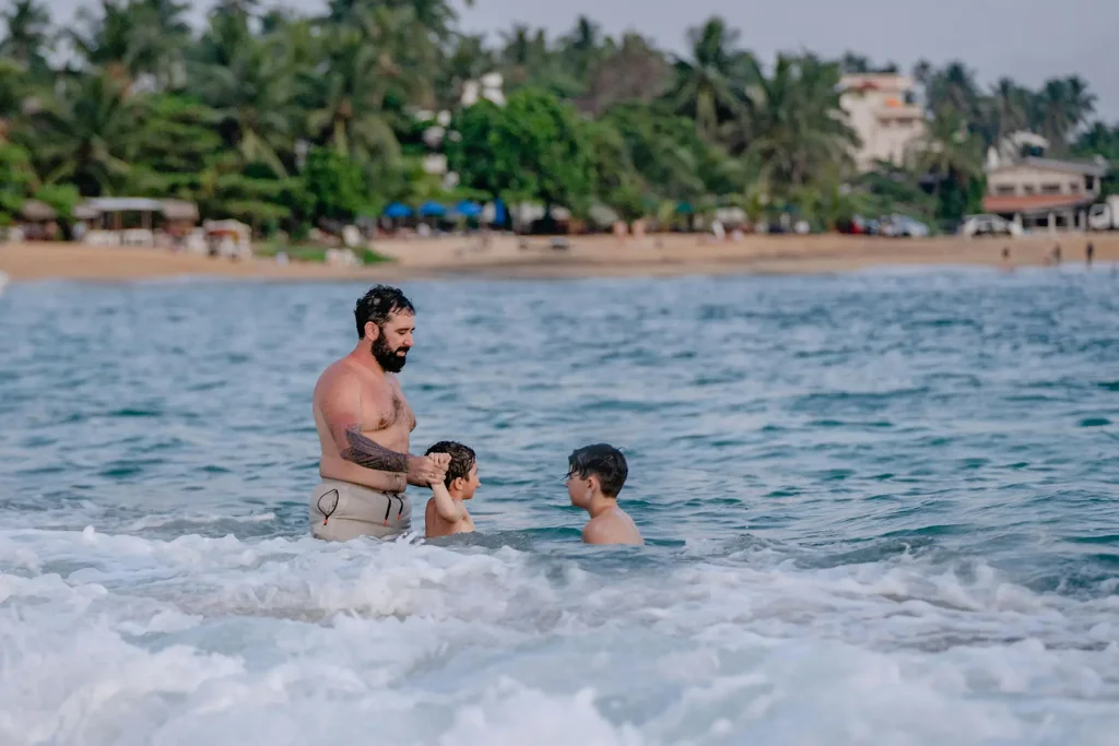 A family enjoys a swim in the ocean at Unawatuna, showcasing the great experience of a family-friendly Sri Lanka vacation